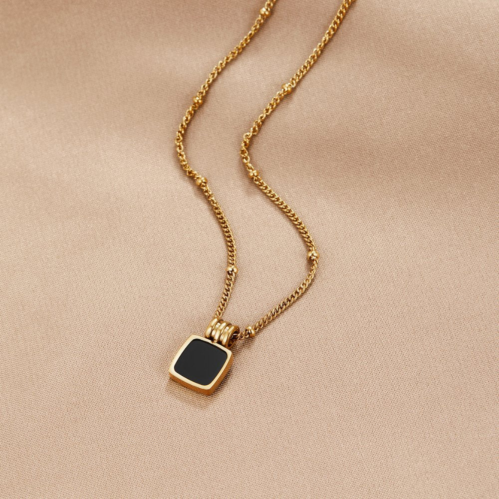 Selina – Collana d'oro con pietra scura.