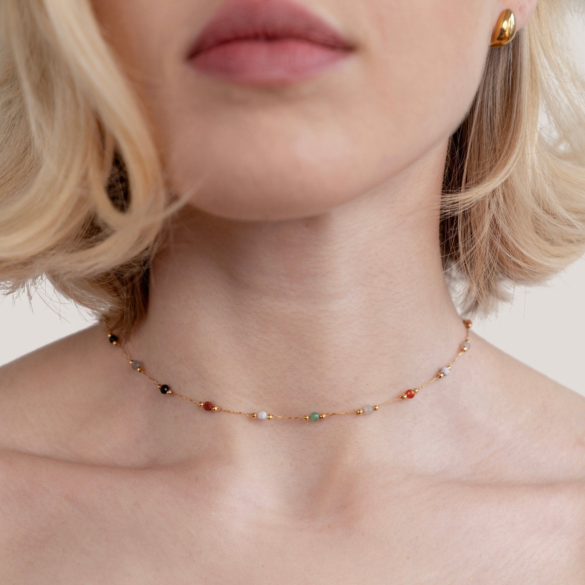 Helmina – Collana color oro con dettagli in smalto.